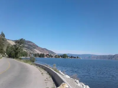 a road next to a large body of water at Grumpy's Suite by the Lake in Summerland