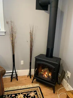 a living room with a black stove in the corner at Sweetest Suite Downtown in Salmon Arm
