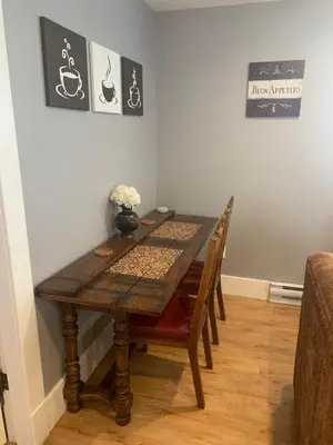 a dining room table and chairs with a table and a vase at Sweetest Suite Downtown in Salmon Arm
