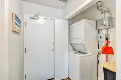 a kitchen with a white refrigerator and a washer and dryer at Luxury 2BR Condo - King Bed - Stunning City Views in Calgary