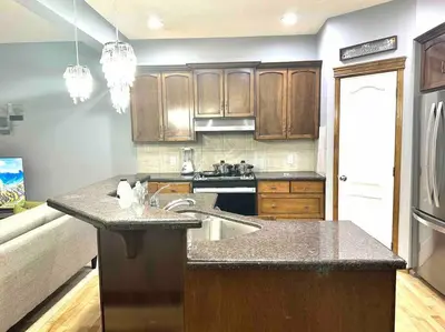 a kitchen with wooden cabinets and a counter top at Spacious, 2-story Family-Friendly home in Calgary