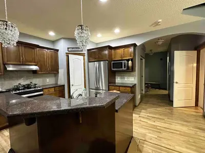 a large kitchen with wooden cabinets and a counter top at Spacious, 2-story Family-Friendly home in Calgary