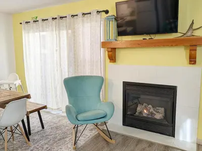 a living room with a chair and a fireplace at Bright 3 bed 3 bath House in Radium Hot Springs in Radium Hot Springs