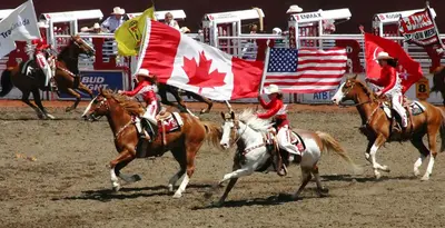 a group of people riding horses with canadian flags at Modern Condo w Balcony - Steps from Stampede Park in Calgary
