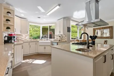 a kitchen with white cabinets and a sink at Grand English Style Home in Chilliwack