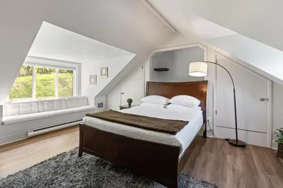 a bedroom with a large bed and a window at Grand English Style Home in Chilliwack