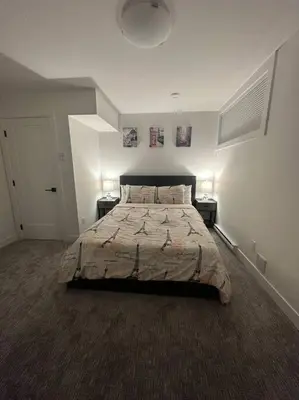 a bedroom with a large bed with two night stands at The Royal Bay Escape: Cozy 2 bedrooms garden suite in Colwood