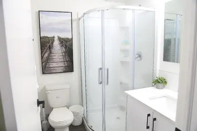a bathroom with a shower and a toilet and a sink at Cozy 3 beds Suite Near Calgary Airport Sleeps 6 in Calgary
