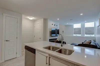 a kitchen with a sink and a counter top at Cozy New Suite in Seton, South Calgary in Calgary