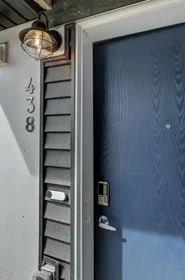 a blue door with a staircase next to a house at Cozy New Suite in Seton, South Calgary in Calgary