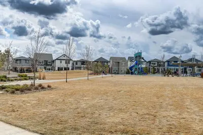 a park with a playground in front of houses at Cozy New Suite in Seton, South Calgary in Calgary