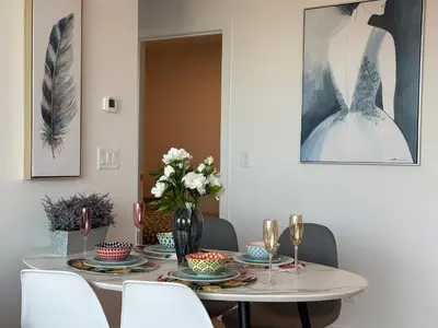 a dining room with a table with a dress on the wall at Pacific Sweet Place @Metro in Burnaby