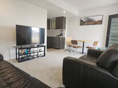 a living room with a couch and a flat screen tv at Praise bethel -Homely walkout legal basement in YYC in Calgary