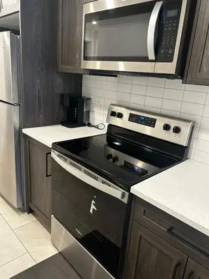 a kitchen with a stove and a microwave at Praise bethel -Homely walkout legal basement in YYC in Calgary