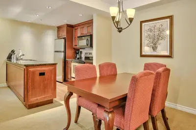 a kitchen with a wooden table and pink chairs at Residences at the Sun Peaks Grand in Sun Peaks