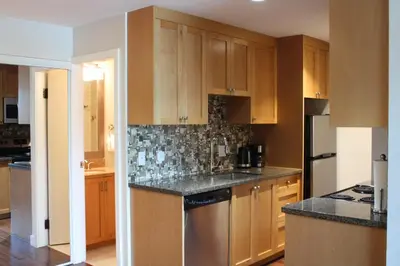 a kitchen with wooden cabinets and a stainless steel appliance at The Après Suite in Whistler