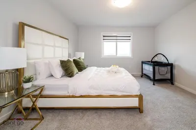 a bedroom with a large white bed and a desk at Orchards Retreat, AC, Family Friendly, Sleeps 10, NearAirprt in Nisku