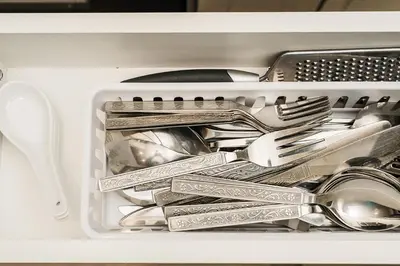 a drawer full of utensils in a dishwasher at Modern suite near Airport Hospital Henday Town Ctr in Nisku