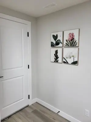 a white room with a door and pictures on the wall at Serene Haven - 1 bedroom apartment. in Calgary