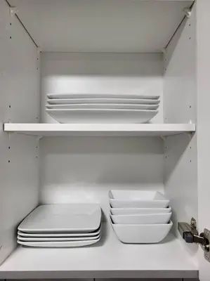 a white refrigerator with plates and bowls on a shelf at Serene Haven - 1 bedroom apartment. in Calgary