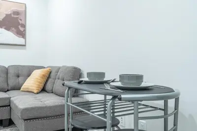 a table with two cups on it next to a couch at Stylish Getaway 2BD Basement by YMCA and South Health Campus Hospital in Calgary