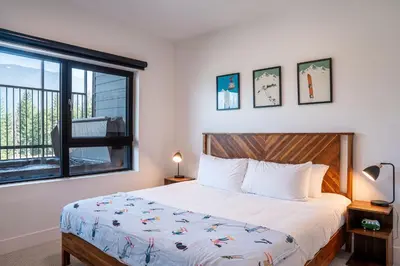 a bedroom with a large bed and a window at Slopes and Greens by Revelstoke Vacations in Revelstoke
