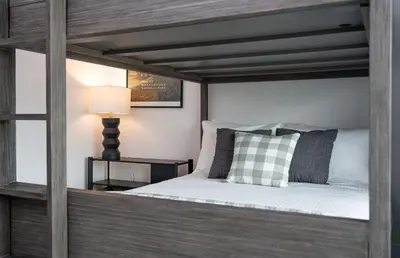 a bedroom with a wooden bed with a pillow and a lamp at The Monashee House by Revelstoke Vacations in Revelstoke