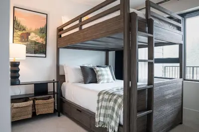 a bedroom with a wooden bunk bed with a ladder at The Monashee House by Revelstoke Vacations in Revelstoke