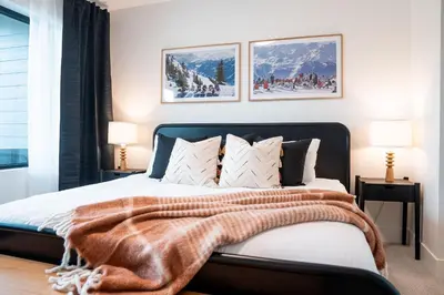 a bedroom with a bed with a blanket on it at The Monashee House by Revelstoke Vacations in Revelstoke