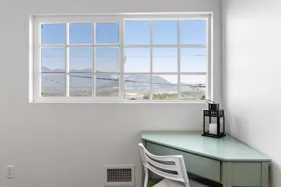 a table and a chair in a room with a window at Private Mountainside Home in Chilliwack