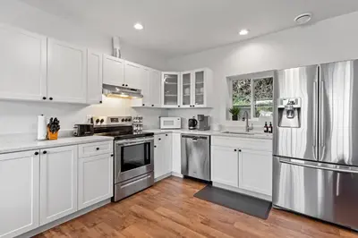 a kitchen with white cabinets and stainless steel appliances at Private Mountainside Home in Chilliwack