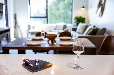 a table with a glass of wine sitting next to a table at Revy's Stellar Retreat in Revelstoke