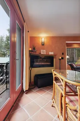 a living room with a table and a balcony at Salt Spring Carriage House B&B in Ganges
