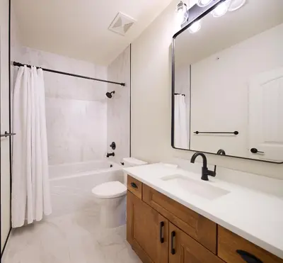 a bathroom with a sink and a toilet and a mirror at Lakeside Luxe Haven in West Kelowna