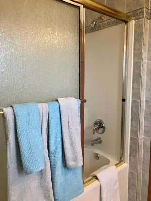 a bathroom with blue and white towels on a towel rack at Rocky Mountain View Bed & Breakfast in Cochrane