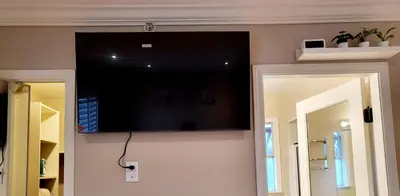 a flat screen tv on the wall of a room at Vivi's Home in Vancouver