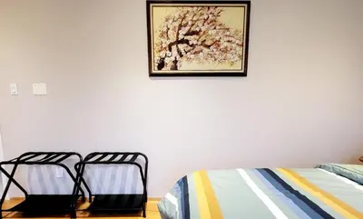 two beds in a room with a picture on the wall at Vivi's Home in Vancouver