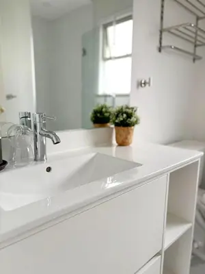 a white bathroom with a sink and a mirror at Vivi's Home in Vancouver