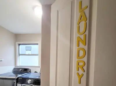 a room with a stove and a sign on the wall at Vivi's Home in Vancouver