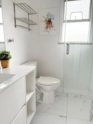 a white bathroom with a toilet and a shower at Vivi's Home in Vancouver