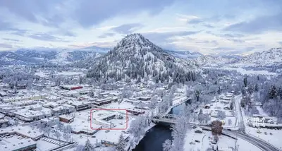 a city covered in snow with a mountain in the background at Granby River Inn & Suites in Grand Forks