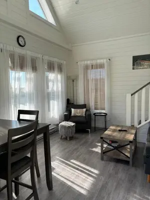 a living room with a table and a couch at Sunrise Cabin- The Loft - secluded Beach front guest house in Sandspit