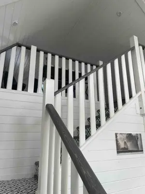 a white staircase in a house with a picture at Sunrise Cabin- The Loft - secluded Beach front guest house in Sandspit