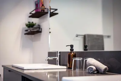 a kitchen counter with a sink and a bottle of wine at The Three Bear Penthouse - with Hot Tub in Revelstoke