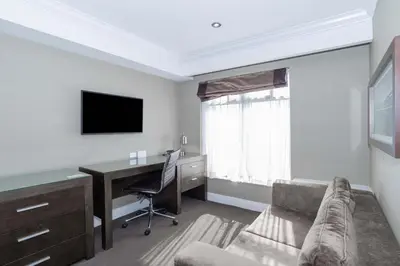 a room with a desk and a computer and a couch at Sandman Signature Kamloops Hotel in Kamloops