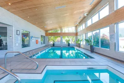 a swimming pool in a house with a wooden ceiling at Sandman Signature Kamloops Hotel in Kamloops