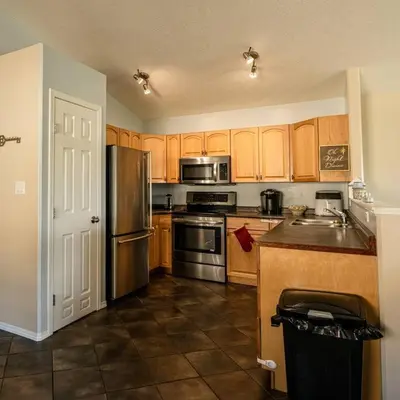 a kitchen with wooden cabinets and stainless steel appliances at Pink door-ed wonder in Grande Prairie