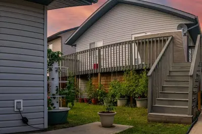 a house with a staircase and potted plants at Pink door-ed wonder in Grande Prairie