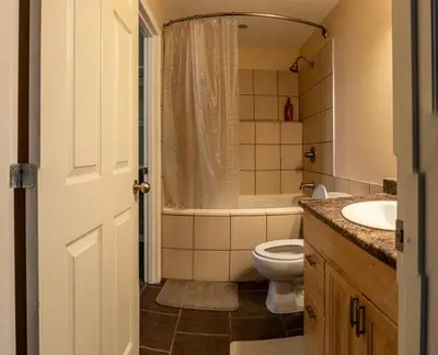 a bathroom with a toilet and a tub and a sink at Pink door-ed wonder in Grande Prairie