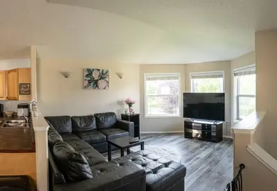 a living room with a couch and a flat screen tv at Pink door-ed wonder in Grande Prairie